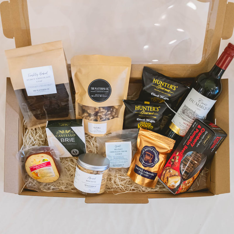 food hamper with wine, smoked dutch cheese, brie, nuts, hunter's chips, the kettle gourmet popcorn, ob finest fruit and nut crackers, chocolate chip cookie